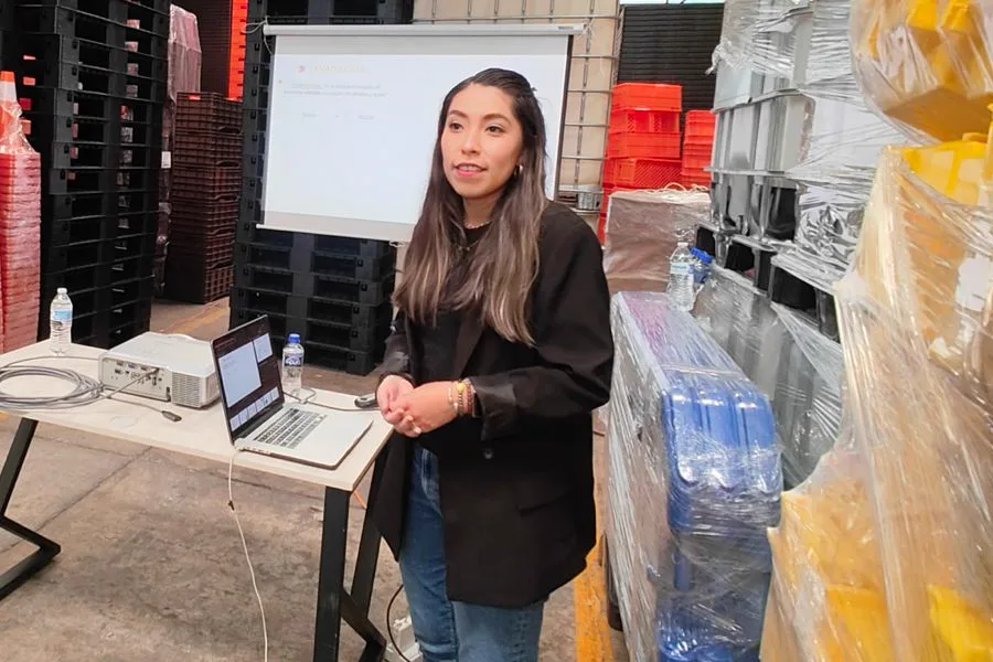 Sandy dando una ponencia de tanatología frente a una pantalla de proyección