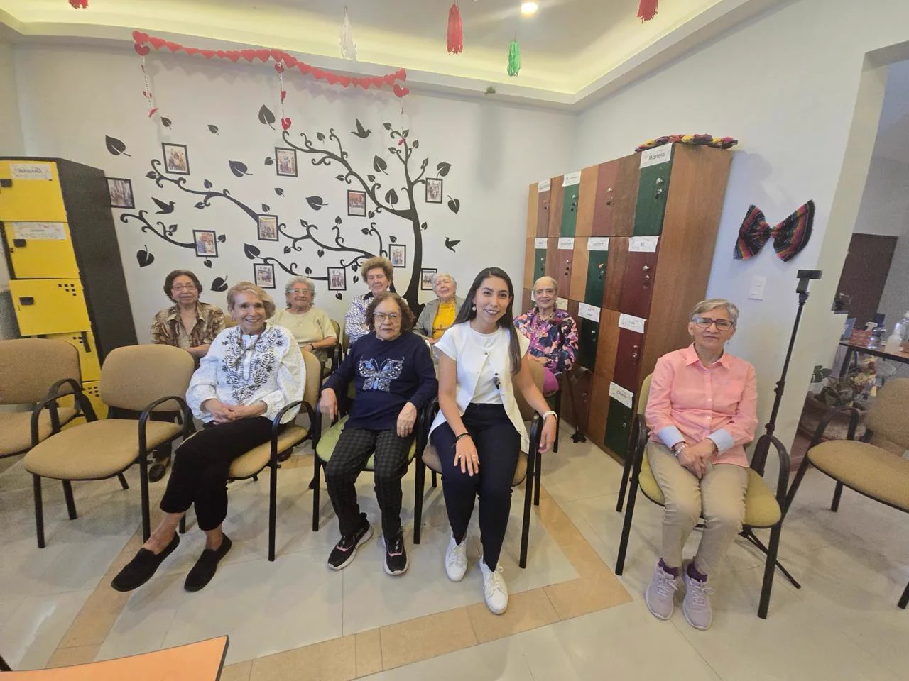 Sandy con el grupo de adultos mayores del taller, todos sentados de frente